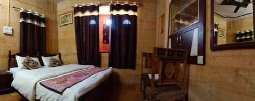 a bedroom with a bed and a window with curtains at Hotel Fotiya jaisalmer in Jaisalmer
