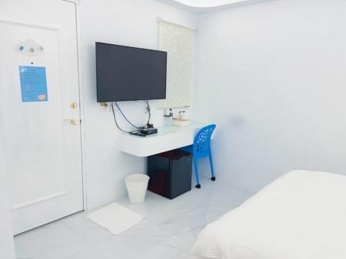 a bedroom with a desk and a tv on a wall at Sky Grass in Nanwan