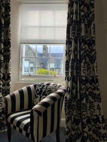 a window with a couch in front of a window at The Original Rosslyn Inn in Roslin