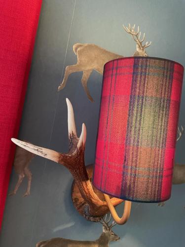 a plaid lamp with a deer on the wall at The Original Rosslyn Inn in Roslin