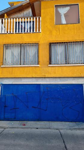 a blue wall with graffiti on it in front of a building at Casas y cabañas Nofal in Los Vilos