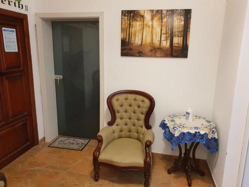 a room with a chair and a table with a candle at Apartments Fazarinc with parking, wellness and city store in the center of Celje in Celje