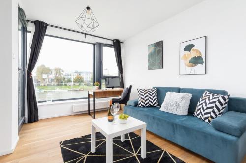 sala de estar con sofá azul y mesa en Riva Verona Apartments by Renters Prestige en Cracovia