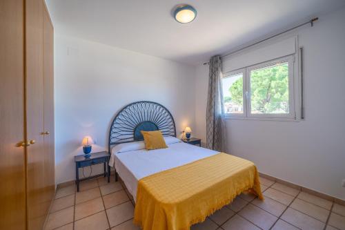 Schlafzimmer mit einem Bett und einem Fenster in der Unterkunft Holiday Home Dakota in L'Escala