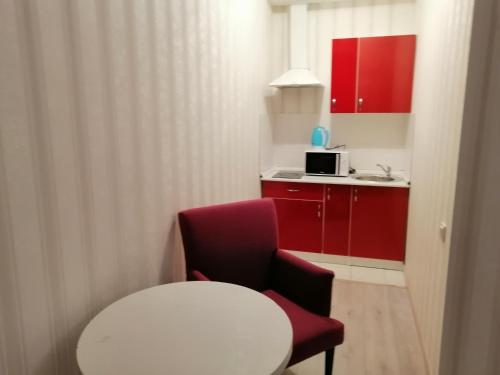 a small room with a white table and a red chair at Apart Hotel Триумф Астаны 22 этаж, Секция 2 in Astana