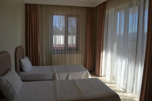 a hotel room with two beds and a window at Almasa Suite Aparts in Termal
