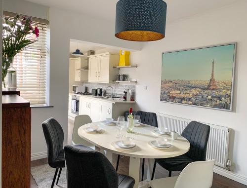 a dining room with a table and chairs and a kitchen at The Kensingston - Quaint Victorian Home With Free Parking in York
