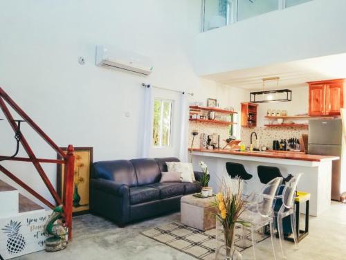 a living room with a couch and a kitchen at Sunsets At Tiffany's in Treasure Beach