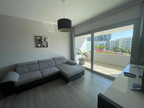 a living room with a couch and a large window at Pool view apartment in Funchal