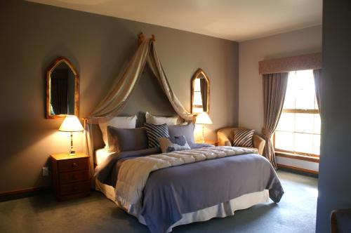 a bedroom with a large bed and two windows at Fyffe Country Lodge in Kaikoura