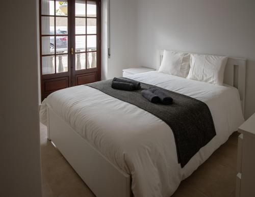 a bedroom with a bed with two slippers on it at Cascais Center Apartment - 500 m from the beach in Cascais