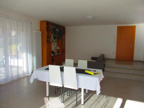 comedor con mesa y sillas blancas en Casa Mirella (cipat 022236-AT-849841), en Vigolo Vattaro