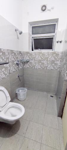 a bathroom with a toilet and a window at Suvarna Elite - Premium Apartment Hotel in Mysore