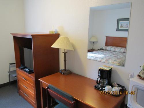 a hotel room with a bed and a television at Lazy J Motel in Claresholm