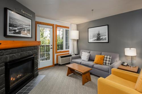 a living room with a couch and a fireplace at Lodge de la Montagne in Mont-Tremblant