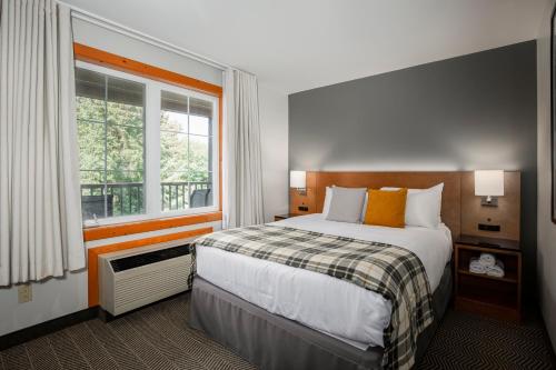 a hotel room with a bed and a window at Lodge de la Montagne in Mont-Tremblant