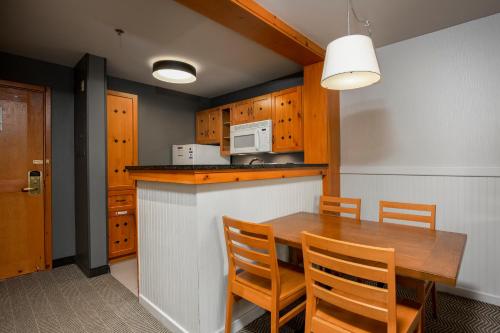 a kitchen with a wooden table and chairs at Lodge de la Montagne in Mont-Tremblant