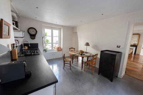 une cuisine et une salle à manger avec une table et des chaises dans l'établissement Roulette, à Paris