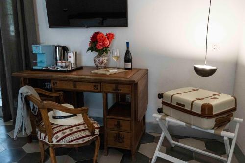 a desk with a bottle of wine and a suitcase at Dattilo in Torre Melissa