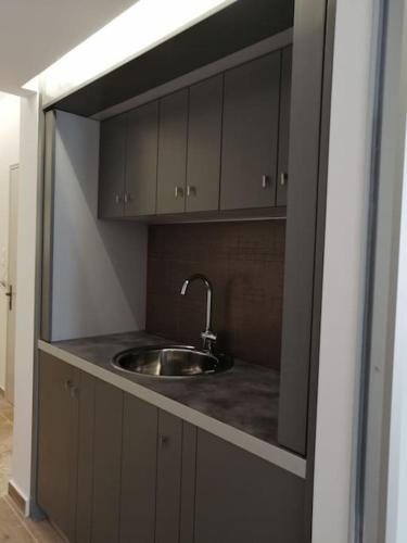 a kitchen with a sink in a counter top at Aegina Port Apt 4 in Egina
