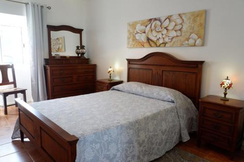 a bedroom with a bed and a painting on the wall at Coastal Trail Cottage in São Vicente Ferreira