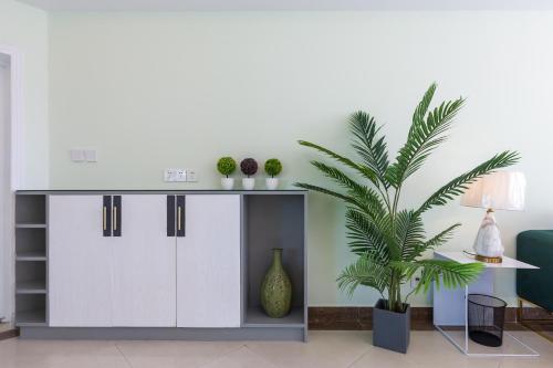 a living room with a table and a plant at Sanya Sun Seaview Apartment in Sanya