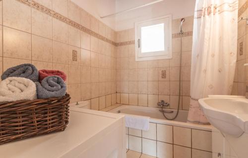 La salle de bains est pourvue d'un lavabo et d'une baignoire. dans l'établissement Ilia's Holiday Home, à Perítheia