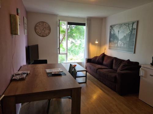 uma sala de estar com uma mesa e um sofá em Johan's B&B met dakterras - since 2014 em Amsterdã