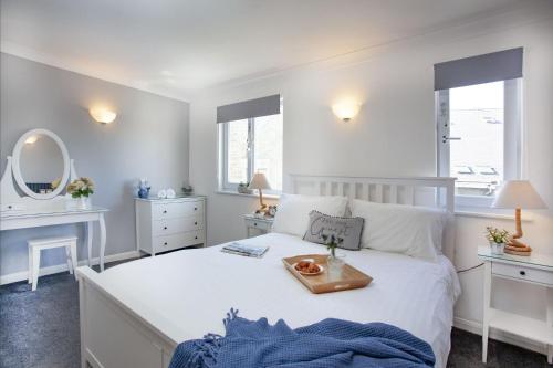 a bedroom with a white bed with a tray on it at Atlantic View, Penzance in Penzance