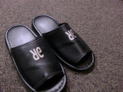 a pair of black shoes sitting on the floor at Green Rich Hotel Suizenji in Kumamoto