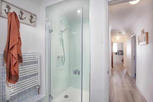 a glass shower in a bathroom with a hallway at Atlantic View, Penzance in Penzance