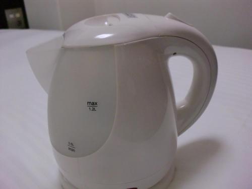 a white tea kettle sitting on a table at Green Rich Hotel Suizenji in Kumamoto