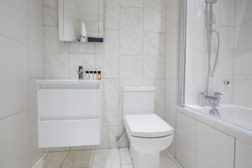 biała łazienka z toaletą i umywalką w obiekcie 1VH Virginia House, 31 Bloomsbury Way by City Living London w Londynie
