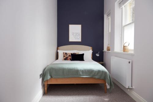 a bedroom with a bed with blue walls at 1VH Virginia House, 31 Bloomsbury Way by City Living London in London