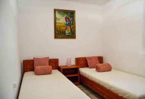um quarto com duas camas e uma foto na parede em Irma- forrás Vendégházak em Kismaros