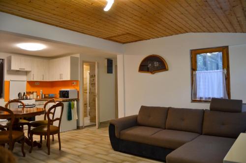 a living room with a couch and a table at Irma- forrás Vendégházak in Verőce