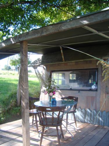 a patio with a table and chairs on a deck at Les Patins à Roulottes in Yenne