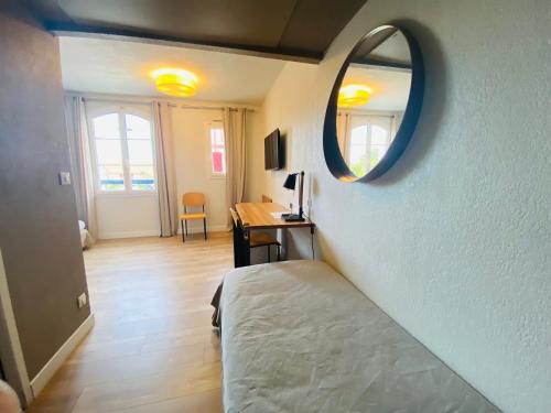 a bedroom with a bed and a desk and a mirror at Hôtel & Appart-hôtel Olatua in Bidart