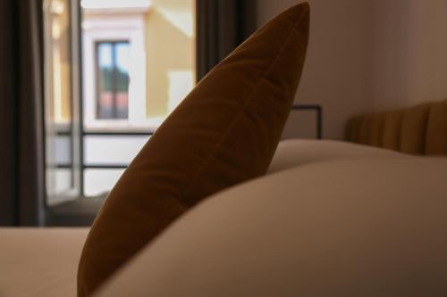 a brown pillow sitting on a bed with a window at Old Town Home Trastevere in Rome