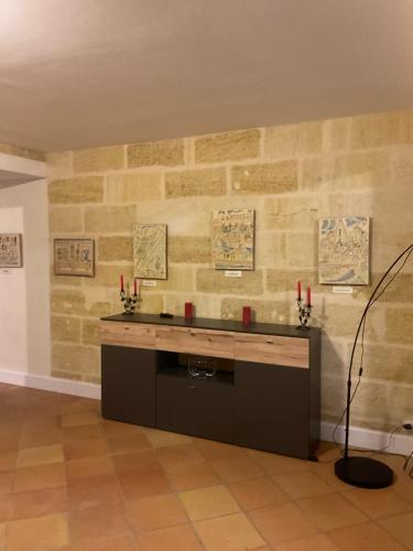 Cette chambre est dotée d'un mur en pierre et d'un bureau. dans l'établissement Pomerol au Cœur, à Pomerol