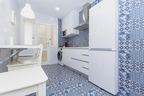 a kitchen with white appliances and blue tiles at Apartamento San Pascual 18 III en Orihuela in Orihuela