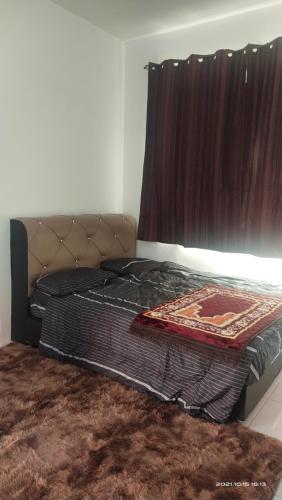 a bed sitting in a room with a window at Homestay De'69 in Jitra