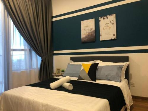 a bedroom with a large bed with a blue wall at KL Gateway Premium Residence I HomeBrickz in Kuala Lumpur