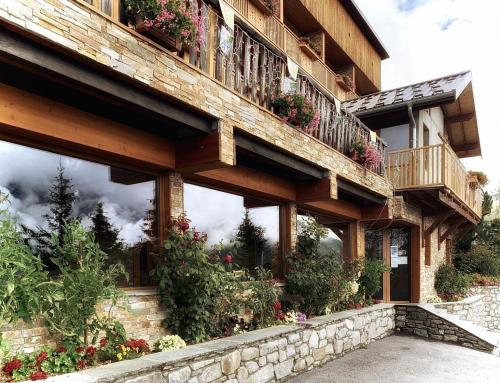 budynek z skrzyniami kwiatowymi i balkonami w obiekcie Hotels Les Catrems & Le Montagnou w mieście Orcières