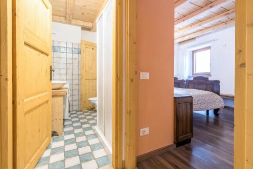 a room with a bathroom and a bedroom with a bed at Agriturismo Al Gallo Nero Rosso in Tenno