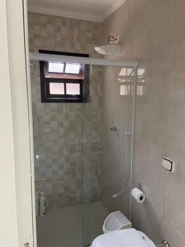 a bathroom with a glass shower with a toilet at casa 300 mts da praia in Juquei