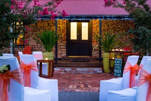 a row of white chairs with bows in front of a door at The Inn Mahogany Creek in Mahogany Creek