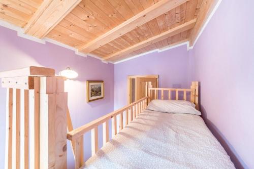 a small bedroom with a bunk bed and wooden ceilings at Agriturismo Al Gallo Nero Lilla in Tenno