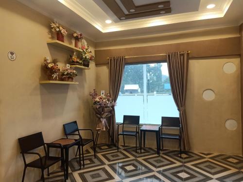 een wachtkamer met stoelen, een tafel en een raam bij Wisma Cemara Dumai in Dumai