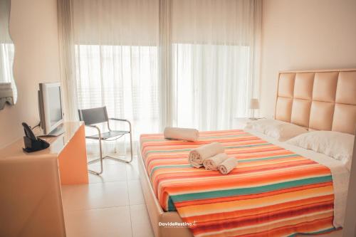 Un dormitorio con una cama grande con toallas. en Minzoni Gallipoli sul mare e 130 mt dal centro, en Gallipoli